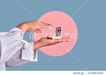 Hands applying face powder from compact case Hands applying face powder from compact case 133662820