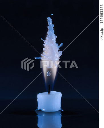 A white candle stub with frozen crystal flame isolated on a dark background. Dramatic freezing fire splash, ice crystals captured mid-air, create an abstract form. Warmth and coldness effect 133663388