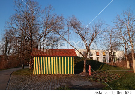 A yellow and green shed sits in front of a white building A yellow and green shed sits in front of a white building 133663679