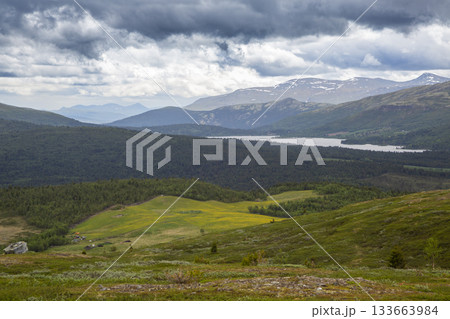 View of serene Lake Flatningen from the flanks of Strondsaeterhoe mountain in Vang, Norway during a cloudy day 133663984