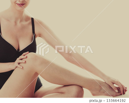 Sitting woman in underwear showing smooth legs Sitting woman in underwear showing smooth legs 133664192
