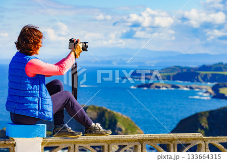 Tourist with camera on Asturias coast, Spain Tourist with camera on Asturias coast, Spain 133664315