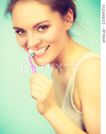 Woman brushing cleaning teeth 133664553