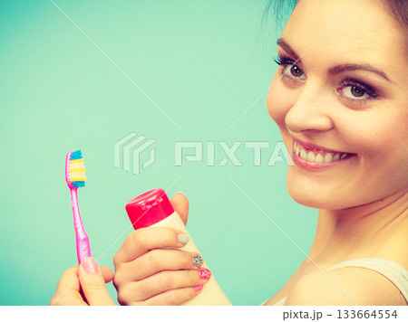 Woman holds toothbrush and paste for teeth cleaning 133664554