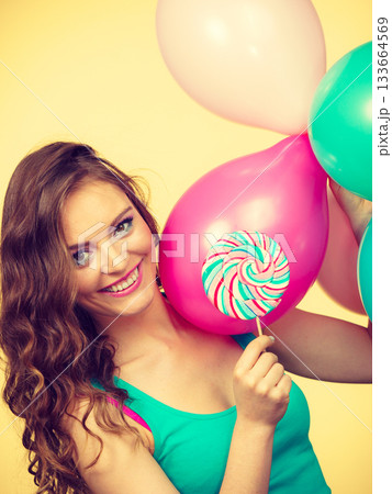 Woman with colorful balloons and lollipop 133664569