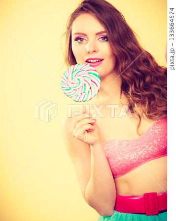 Woman holding colorful lollipop candy in hand. 133664574