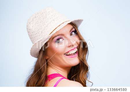 Woman in summer straw hat on head smiling Woman in summer straw hat on head smiling 133664580
