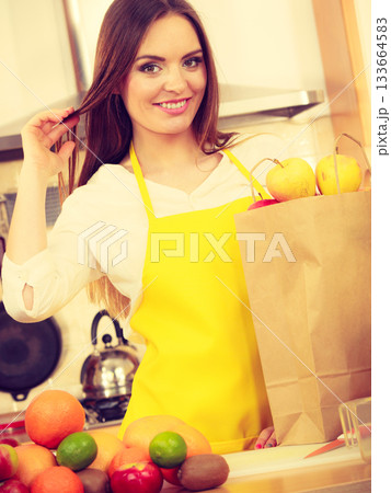 Woman housewife in kitchen with many fruits 133664583