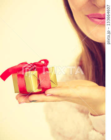 Female hand with golden box gift Female hand with golden box gift 133664607