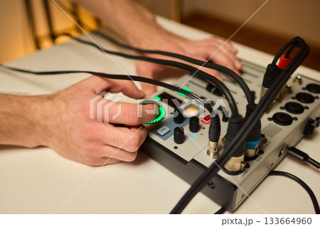 Closeup of tactile controls and vibrant patch cords in studio, Adjusting analog sequencing equipment with bright cables and warm ambient lighting in home studio Closeup of tactile controls and vibrant patch cords in studio, Adjusting analog sequencing equipment with bright cables and warm ambient lighting in home studio 133664960