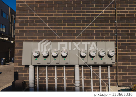 Row of smart electric meters on brick wall measuring residential energy consumption Row of smart electric meters on brick wall measuring residential energy consumption 133665336