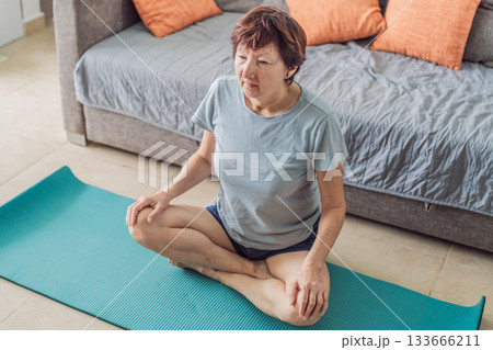 Elderly woman practicing yoga in her cozy living room, stretching on a mat and maintaining balance. Concept of healthy aging, active senior lifestyle, mindfulness, wellness, and daily home exercise Elderly woman practicing yoga in her cozy living room, stretching on a mat and maintaining balance. Concept of healthy aging, active senior lifestyle, mindfulness, wellness, and daily home exercise 133666211