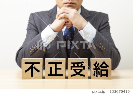 「不正受給」と書かれたブロックとビジネスマン 「不正受給」と書かれたブロックとビジネスマン 133670419