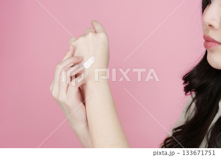 Skincare application. Young woman testing cream on her wrist. 133671751