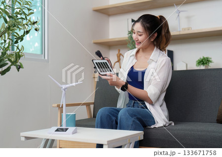 Renewable Energy: Woman Exploring Solar Technology at Home 133671758