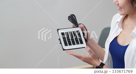 Solar energy. Woman holding a solar panel for sustainable power. 133671769