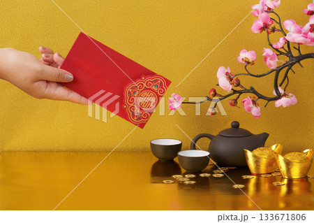 Chinese New Year with red envelope and tea set on golden background 133671806