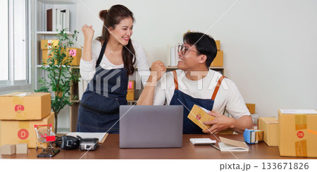 E-commerce Success. Young entrepreneurs celebrating achievement in a startup office. E-commerce Success. Young entrepreneurs celebrating achievement in a startup office. 133671826