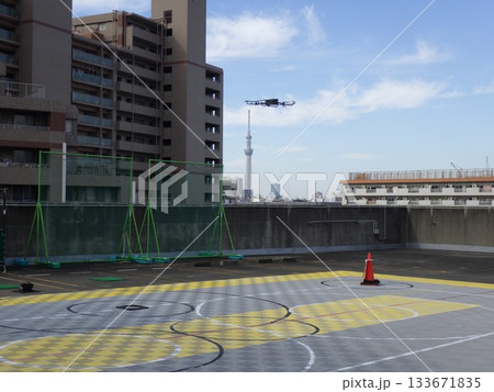 ビルの谷間を飛行するドローン 133671835