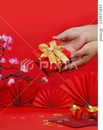 Gift exchange during Chinese New Year with red box and flowers 133671847