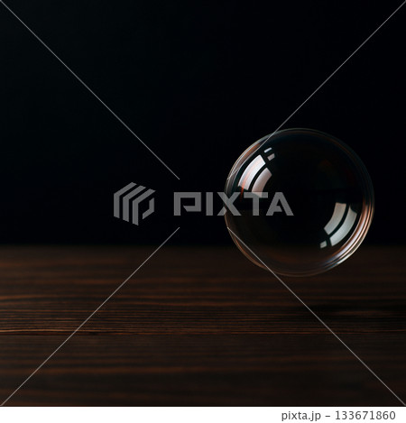 暗い木製テーブルの上を漂うシャボン玉 暗い木製テーブルの上を漂うシャボン玉 133671860