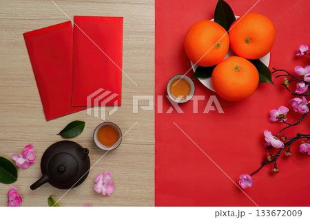 Chinese New Year festive arrangement with red envelopes, oranges, and tea 133672009