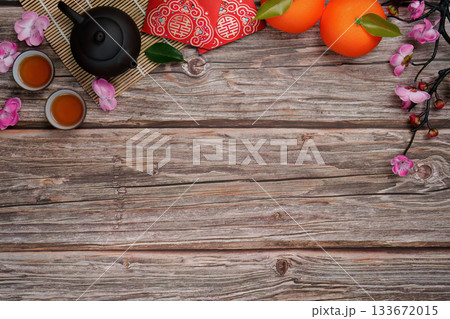Chinese New Year festive setup with tea, oranges, and red envelopes on wooden surface Chinese New Year festive setup with tea, oranges, and red envelopes on wooden surface 133672015