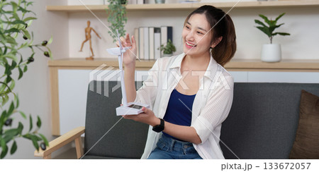 Eco-Friendly Technology. Young woman unboxing renewable energy gadget at home. Eco-Friendly Technology. Young woman unboxing renewable energy gadget at home. 133672057