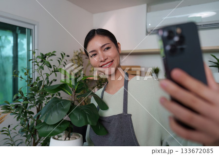 Selfie Moment. Woman taking a selfie with her indoor plant. 133672085