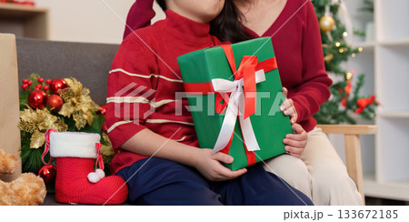 SSTK Christmas. Child holding a beautifully wrapped green gift box. SSTK Christmas. Child holding a beautifully wrapped green gift box. 133672185
