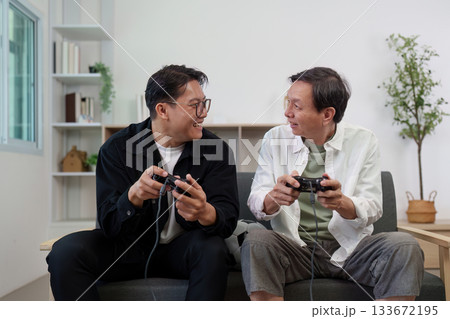 Hobby Family: Engaging in video games, two men sharing a fun moment. 133672195