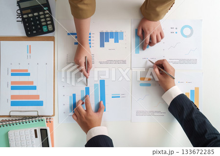 Data Analysis. Team reviewing financial graphs and statistics on a table. 133672285