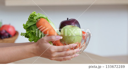 Food Wellness: Holding a Bowl of Fresh Fruits and Vegetables 133672289