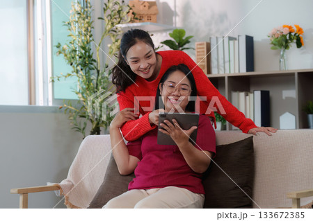 Digital connection. Young woman and her mother sharing moments on a tablet. 133672385