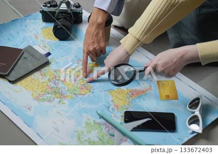 Travel Planning. Friends discussing their trip with a map, camera, and travel essentials. Travel Planning. Friends discussing their trip with a map, camera, and travel essentials. 133672403