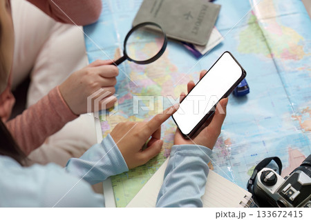 Travel Planning. Friends using a smartphone while planning a trip. Travel Planning. Friends using a smartphone while planning a trip. 133672415