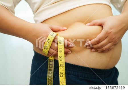 Asian woman with fat belly big size overweight and obesity with measure tape. Asian woman with fat belly big size overweight and obesity with measure tape. 133672469
