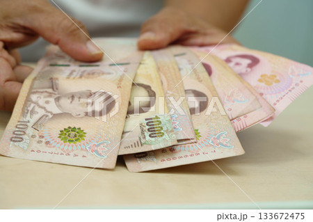 Asian woman counting Thai baht banknote money and holding in hand, investment economy, accounting business and banking. Asian woman counting Thai baht banknote money and holding in hand, investment economy, accounting business and banking. 133672475