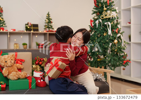 SSTK Christmas. A warm embrace between a child and woman surrounded by festive gifts. 133672479