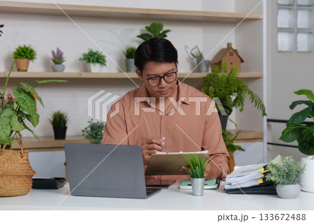 Remote Work. Professional analyzing financial data in a modern home office. Remote Work. Professional analyzing financial data in a modern home office. 133672488