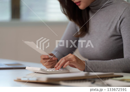 Budgeting: Woman Reviewing Finances with Calculator and Receipt 133672591