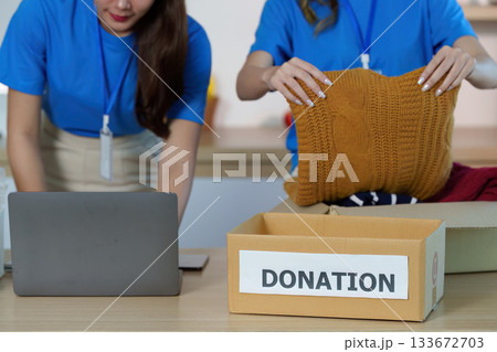 Donation. Volunteers packing clothing items for community support. Donation. Volunteers packing clothing items for community support. 133672703