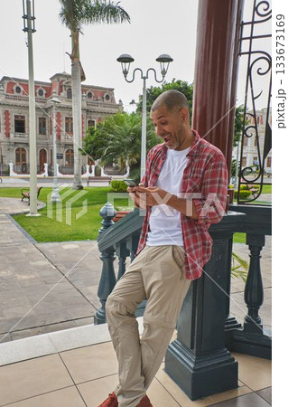 Man tourist having a happy surprise looking at phone Man tourist having a happy surprise looking at phone 133673169