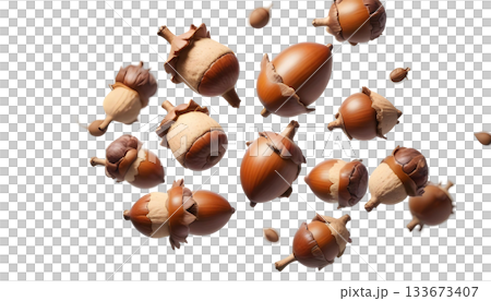 A cluster of acorns falling to the ground amidst late autumn leaves in a natural outdoor setting A cluster of acorns falling to the ground amidst late autumn leaves in a natural outdoor setting 133673407