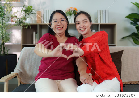 Heartfelt connection. Two women forming a heart shape with their hands. Heartfelt connection. Two women forming a heart shape with their hands. 133673507
