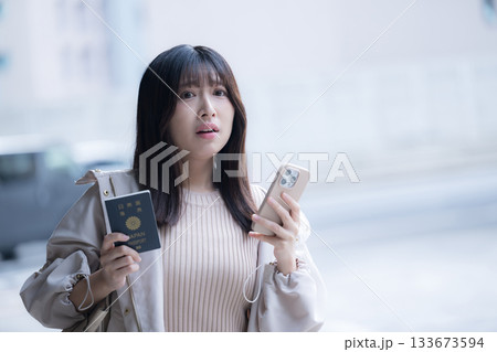 海外で迷子や遅刻、乗り遅れになったり困るパスポートを持つ女性　旅行先でのトラブルイメージ 133673594