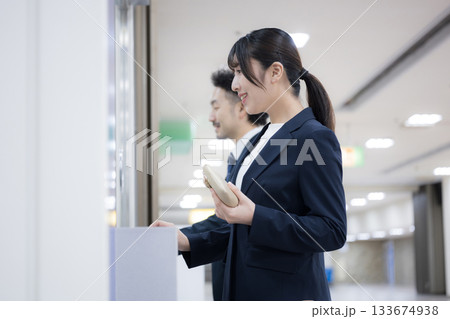 駅や空港などの券売機でチケットを買う出張のビジネス女性 133674938