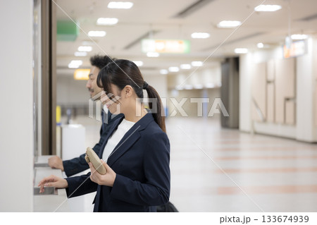 駅や空港などの券売機でチケットを買う出張のビジネス女性 133674939