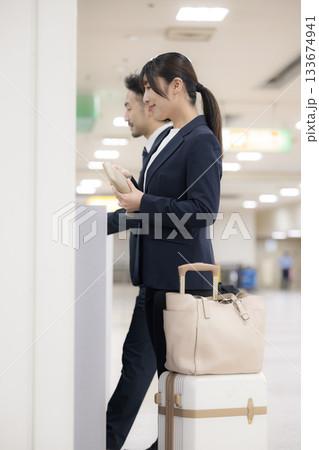 駅や空港などの券売機でチケットを買う出張のビジネス女性 133674941