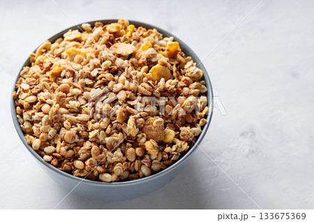 Bowl of Dry Granola Cereal on Gray Background Nutritious Snack Copy Space Bowl of Dry Granola Cereal on Gray Background Nutritious Snack Copy Space 133675369
